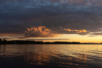 Beautiful panoramic view of sunset on the Volga River. Picturesque sunset landscape on the river. Dramatic sky.