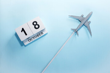 October calendar with number  18. Top view of a calendar with a flying passenger plane. Scheduler....