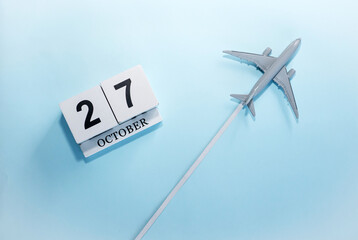 October calendar with number  27. Top view of a calendar with a flying passenger plane. Scheduler....