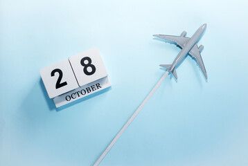 October calendar with number  28. Top view of a calendar with a flying passenger plane. Scheduler....