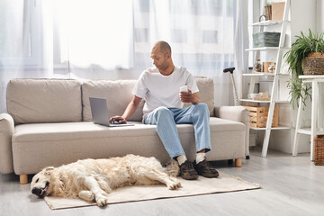 An African American man, living with myasthenia gravis, sits with his loyal Labrador dog on a cozy...