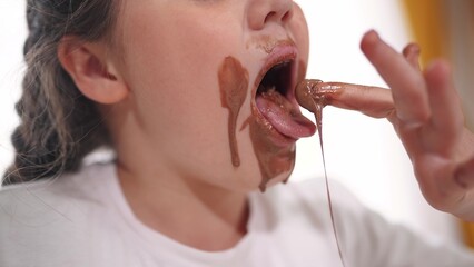 child dirty eating chocolate. unhealthy lifestyle a food for children sweets concept. grimy girl...