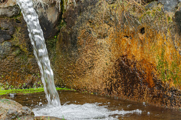 stream of water falling into a stone tank