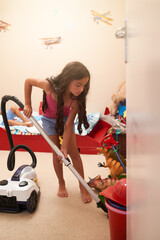 Girl, kid and cleaning bedroom with vacuum, learning housekeeping with chores and responsibility in...