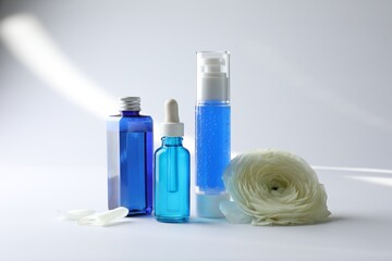 Set of luxury cosmetic products and gentle flower on white background
