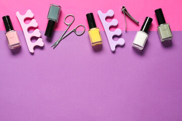 Nail polishes, clippers, scissors and toe separators on color background, flat lay. Space for text