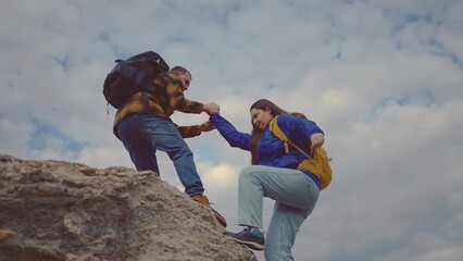 business. teamwork helps hand down a business travel silhouette concept. group climbers helping hand, climbing rocks, mountains. teamwork people climbers climb top. sunlight overcoming difficulties