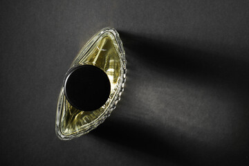Luxury men`s perfume in bottle on black background, top view. Space for text