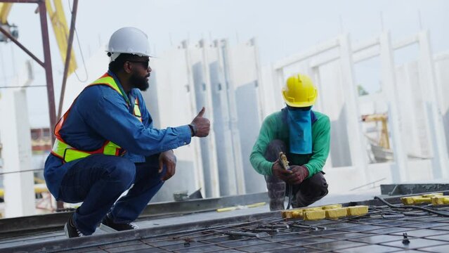 A worker does the welding of reinforcement of concrete structures during the frame construction of a prefabricated concrete walls. Industrial Worker labourer at the factory welding steel structure