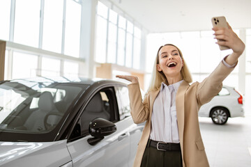 Successful businesswoman taking selfie using smartphone in car service. Happy smiling Caucasian...