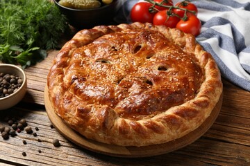 Tasty homemade pie and ingredients on wooden table