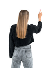 A woman seen from behind pointing upwards, wearing a black sweater and jeans, against a white background