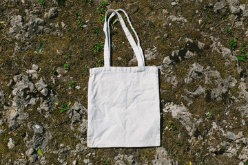 White blank tote mesh bag for shopping on stone, moss and grass background. Mock up, blank eco...