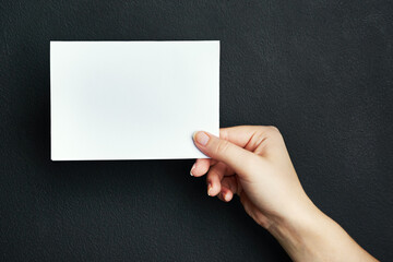 Hand, studio and blank card with mockup space for sale, promotion offer or information about us. Closeup, signage or person with placard for news, announcement or logo advertising on dark background