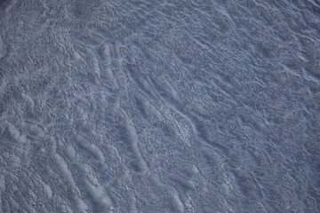 Abstract water surface with ripples and waves as background, top view.