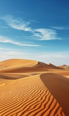 Fototapeta na wymiar A vast expanse of sand dunes in the desert beneath a blue sky, adorned with wisps of clouds