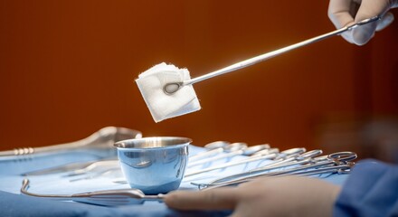 Hand of surgery doctor in Operating Room hold operating plier forceps tweezer pinch gauze and Dip...