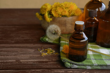 Bottle of dandelion tincture or oil, flower bunch and on a dark table. Herbal medicine. Side view....