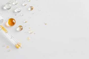 Drops of cosmetic serum and a pipette. A skin care product. White background.