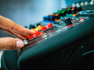Close-up of sound engineer hands adjusting control sound mixer in recording, broadcasting...