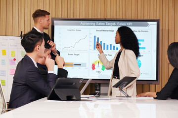 A businessman stands and presents a business plan in a conference room.