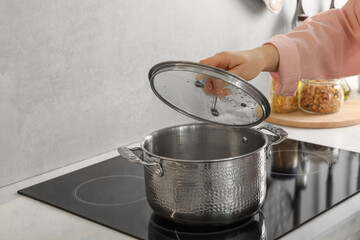 Woman cooking dinner on cooktop in kitchen, closeup