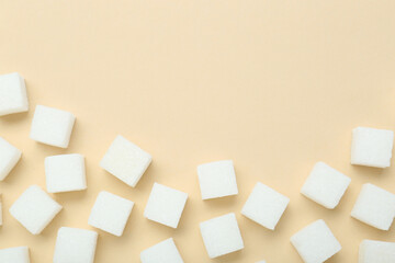White sugar cubes on beige background, top view. Space for text
