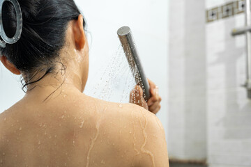 Female in shower rinse shampoo with water dripping on body. Young woman taking shower and washes...