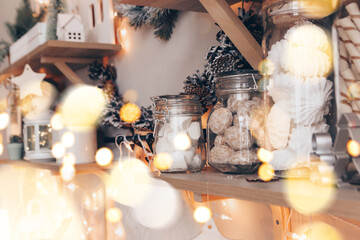 Shelves with glass jars filled with sweets in candy store or coffee shop during Christmas holidays.