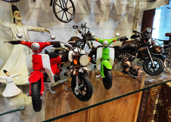 Miniature multicolored vintage motorcycle models in the shop window