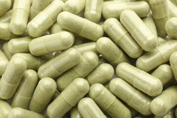 Light green vitamin capsules as background, top view