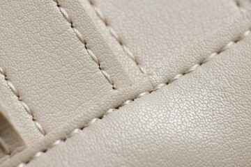 Beige leather with seams as background, closeup view