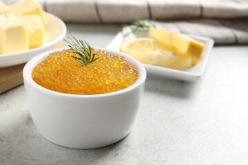 Fresh pike caviar and dill in bowl on light grey table, closeup