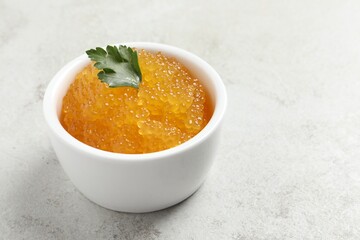 Fresh pike caviar and parsley in bowl on light grey table