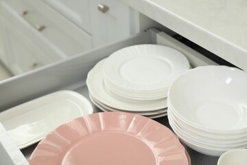 Clean plates and bowls in drawer indoors