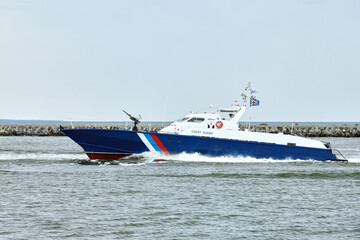 Coast guard ship sails along seaside for safeguarding coastal boundaries and maritime interests...