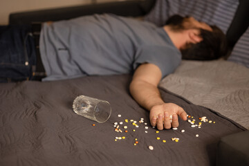 Depressed man commits suicide. Colorful handful drug overdose. Psychological problem, after eaten pills overdose, mental, intoxicated, insomnia, sleep disorder, anxiety, stress concept, many pills - obrazy, fototapety, plakaty