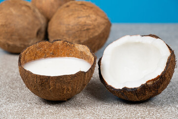 Coconut milk in coconut shell on blue background