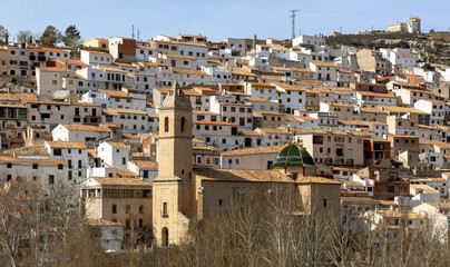 Fototapeta na wymiar Panoramic view of the town of Alcalá del Júcar. Its popular cave houses, carved into the mountain, the castle and Church of San Andrés in the gorge of the júcar rive, Albacete, Spain.