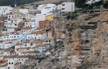 Fototapeta na wymiar Panoramic view of the town of Alcalá del jucar from Las Eras viewpoint. Its popular cave houses, carved into the mountain, the castle and Church of San Andrés in the gorge of the jucar river, Albacete