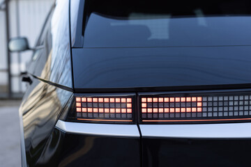 Close up detail on one of the LED red taillight modern luxury car. Car back lights shining....