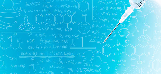 Close-up of syringe on science background,Glass bottle with vaccine and syringe on blue background, close up,Hand drawn science formulas on chalkboard for background