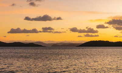 Sunset on the water with island hills on the horizon