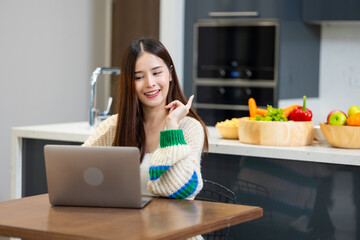 Happy woman relaxing at home - young Asian woman Relaxed working with computer at home. remote...