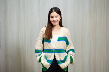 Portrait People lifestyle concept - Asian young woman in white and green winter knitted sweater shirt standing wood wall background