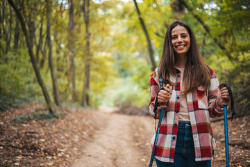 Happy woman with a backpack spending a day in nature, a portrait. Young woman hiking and going camping in nature. Person with backpack walking in the forest - 786263816