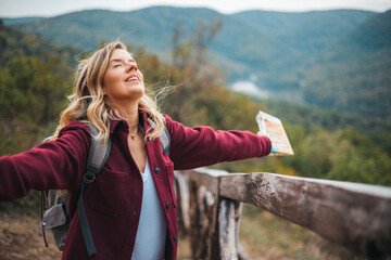 Woman contemplating a beautiful landscape. Young woman breathing pure air in a forest. Young woman hiking and going camping in nature. Person with backpack walking in the forest - 786265255