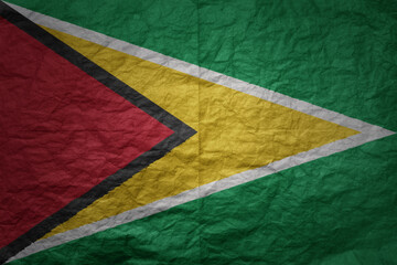 big national flag of guyana on a grunge old paper texture background