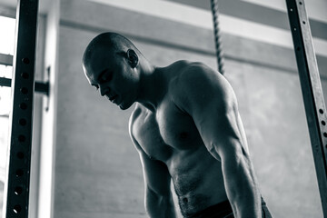 in the gym bald trainer does push-ups on the horizontal bar for push-ups and pull-ups