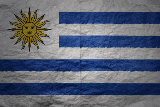 big national flag of uruguay on a grunge old paper texture background